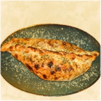 Dubbelgevouwen pizza met shoarmavlees, paprika, uien, champignons en 2 bakjes knoflooksaus